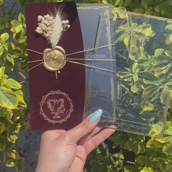 Video of a Burgundy Velvet Half Fold Wedding Invitation with Acrylic Insert Card, Gold Foil details, wax seal and flowers