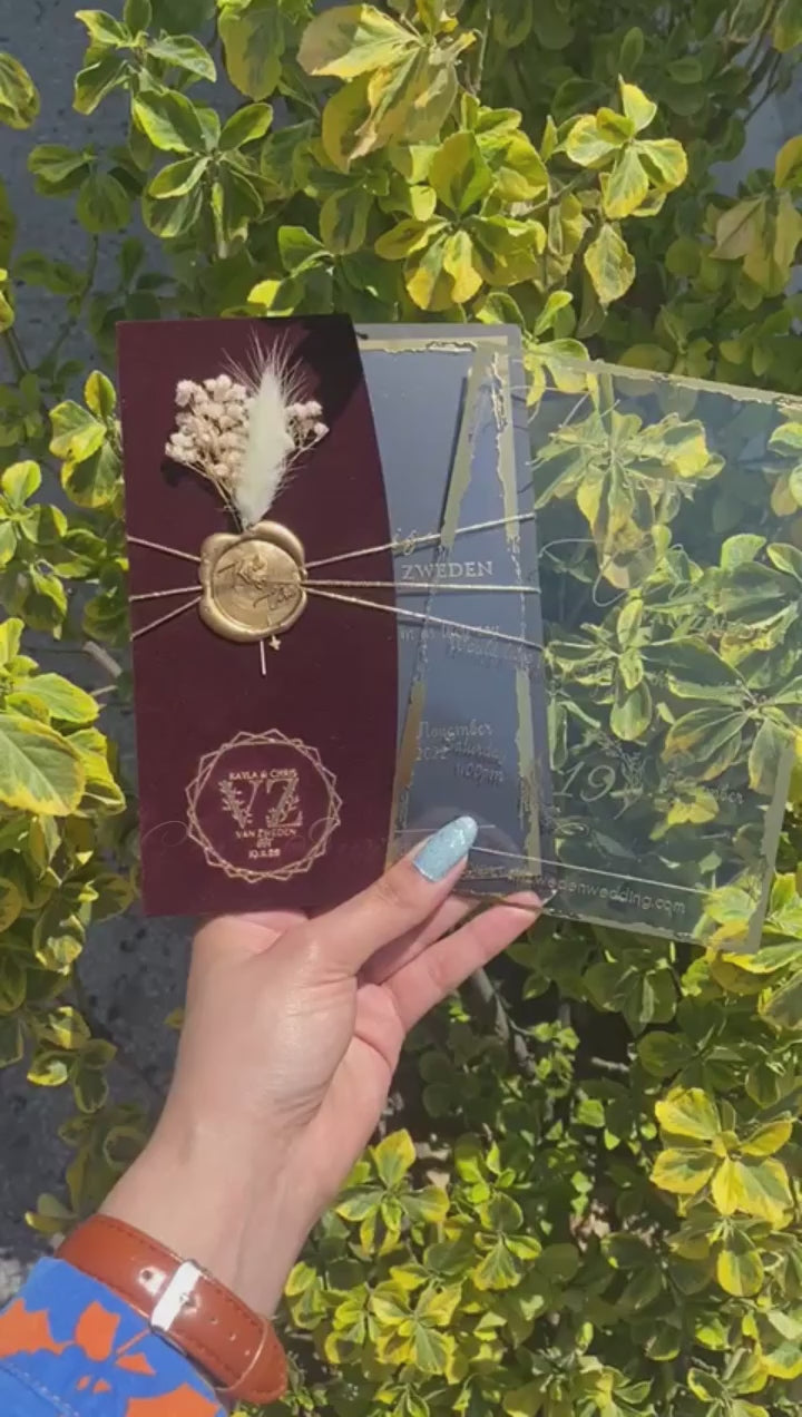 Video of a Burgundy Velvet Half Fold Wedding Invitation with Acrylic Insert Card, Gold Foil details, wax seal and flowers